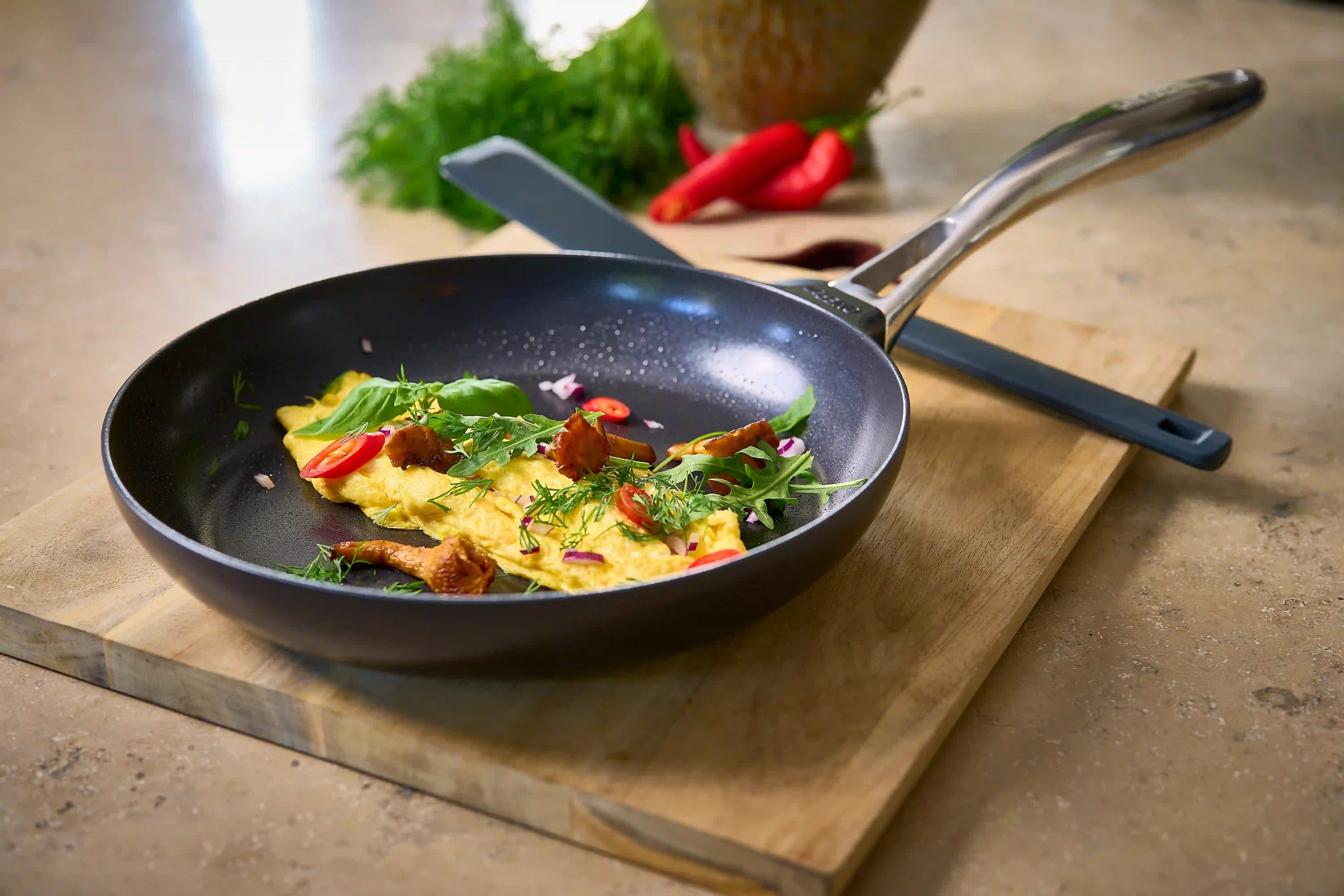 Svart stekpanna med keramisk non-stick och handtag, med stekt mat i pannan