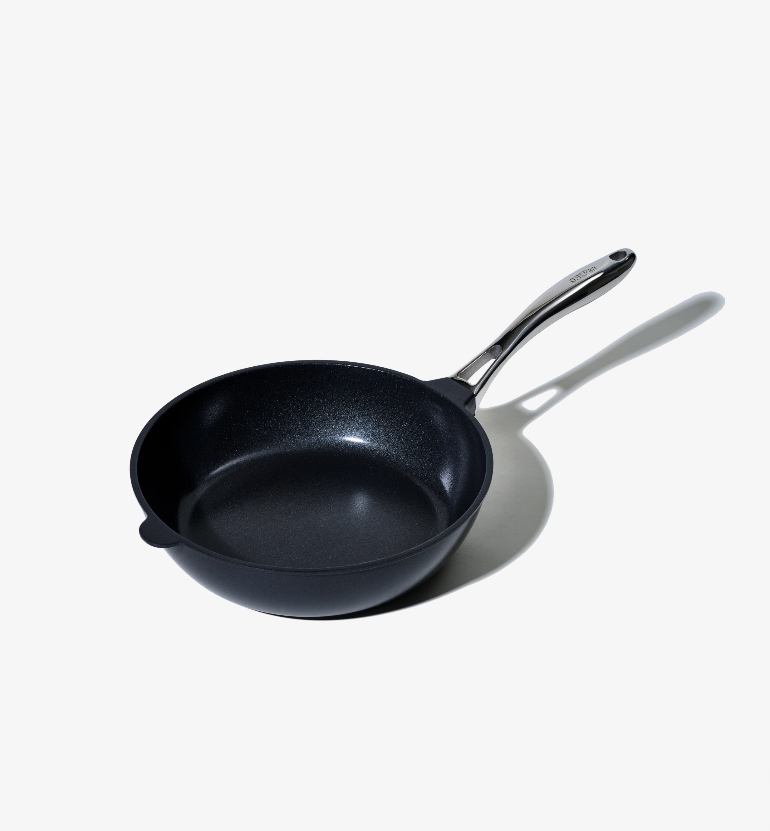 Svart stekpanna med avlångt handtag och rund botten.