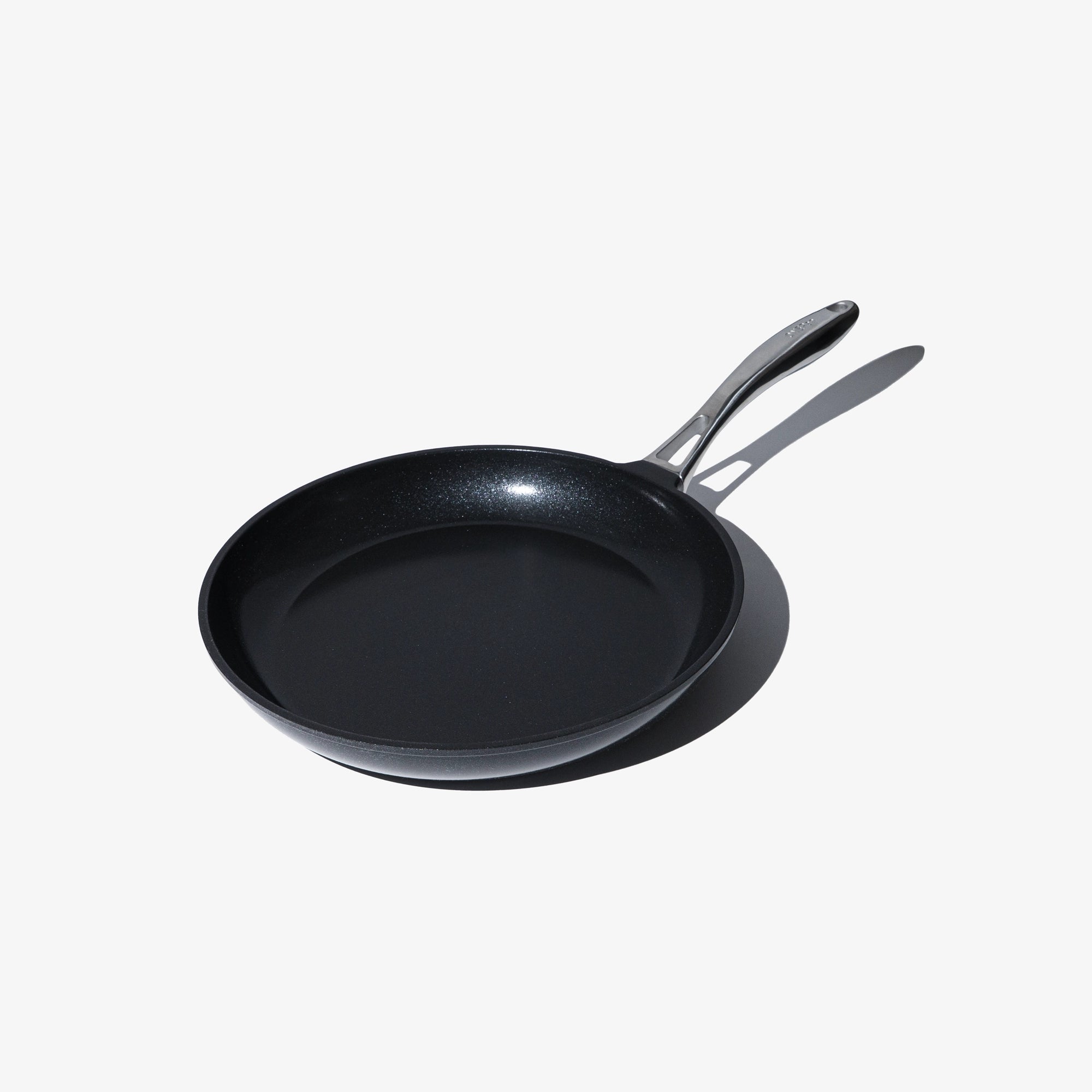 Svart stekpanna med två handtag och platt non-stick stekyta