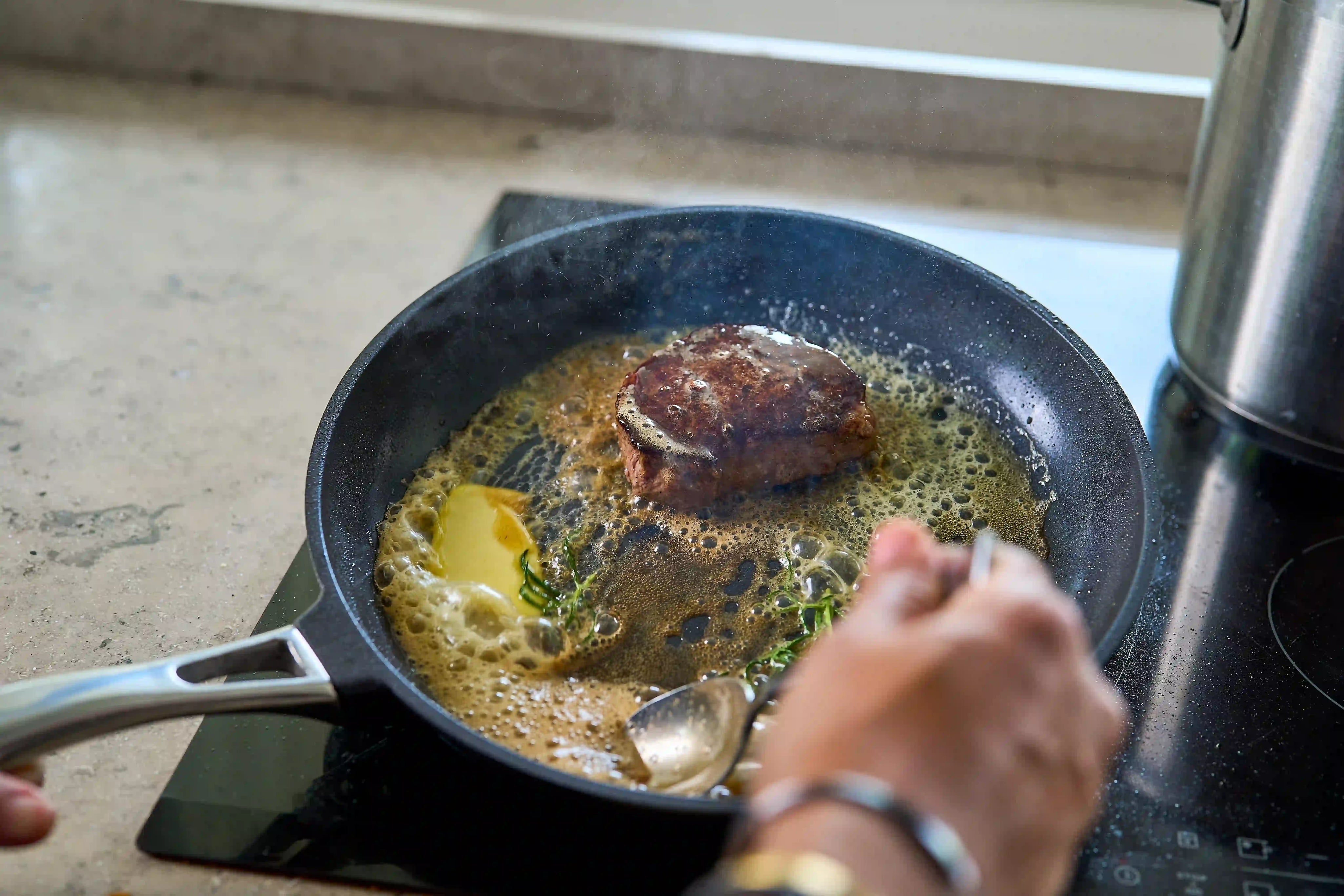 Svart keramisk non-stick stekpanna med handtag, använd vid stekning