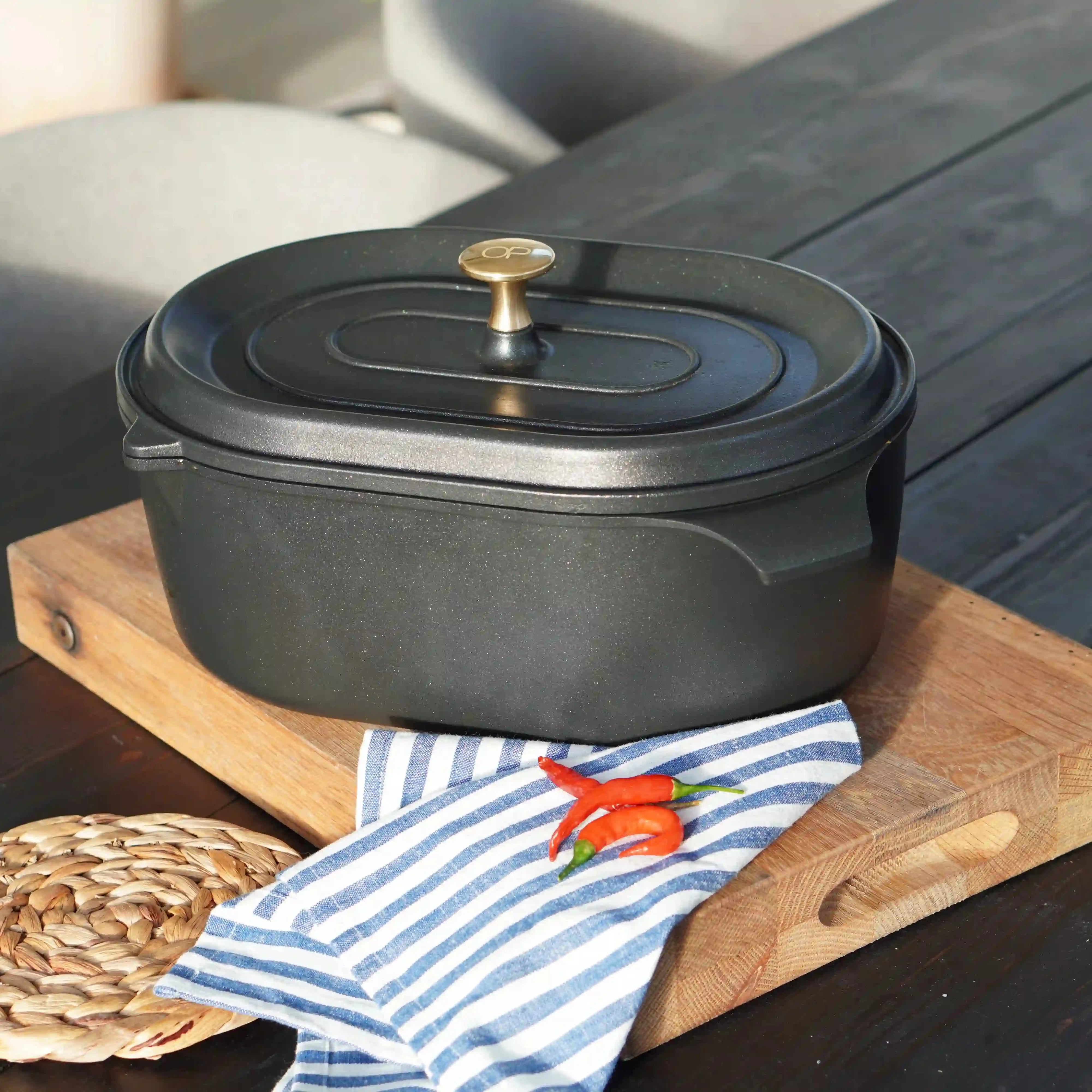 Svart gryta med lock och mässingsfärgad knopp, på träbricka, non-stick OnePot