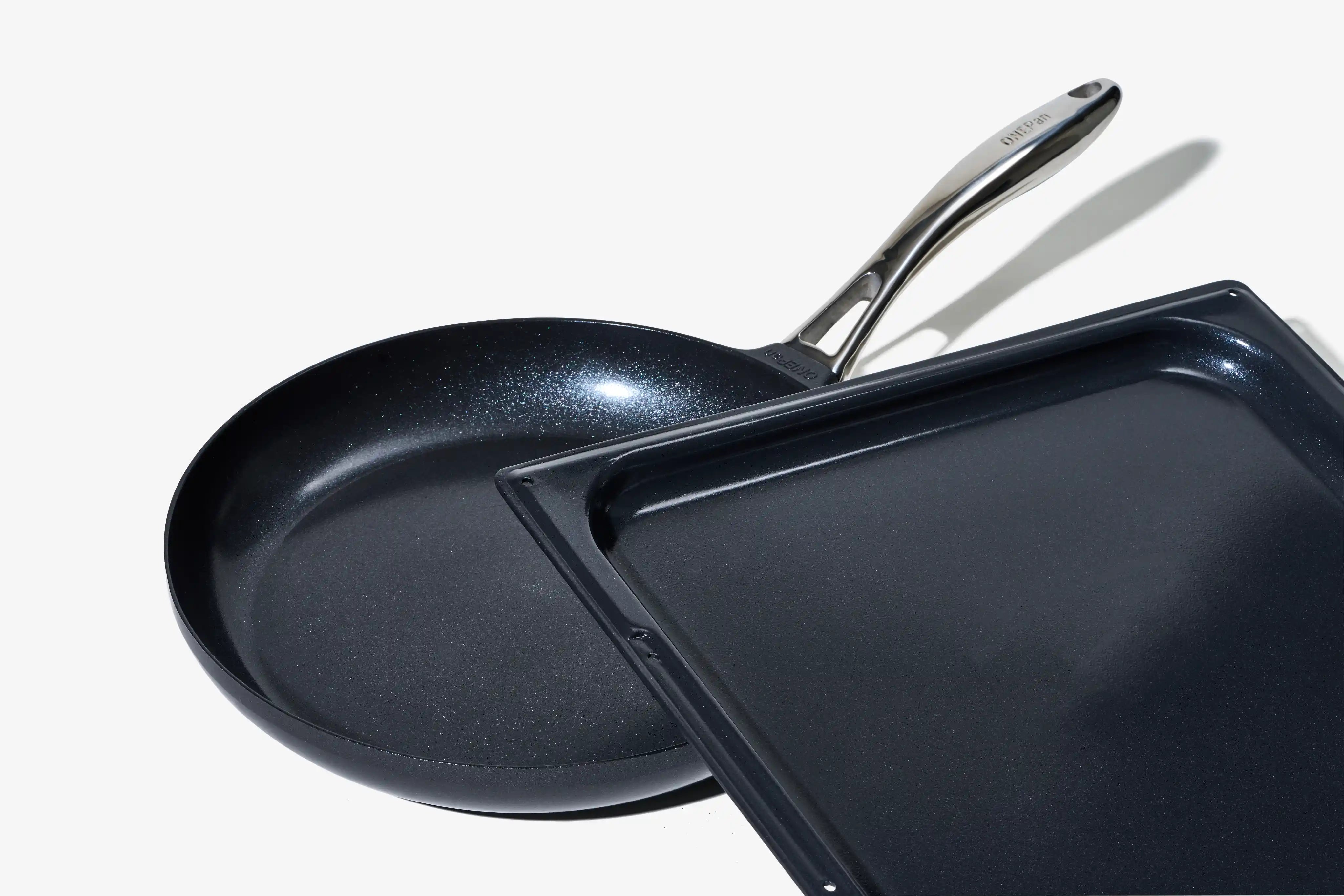 Stekpanna och pizzaplåt i mörk non-stick, med metallhandtag.